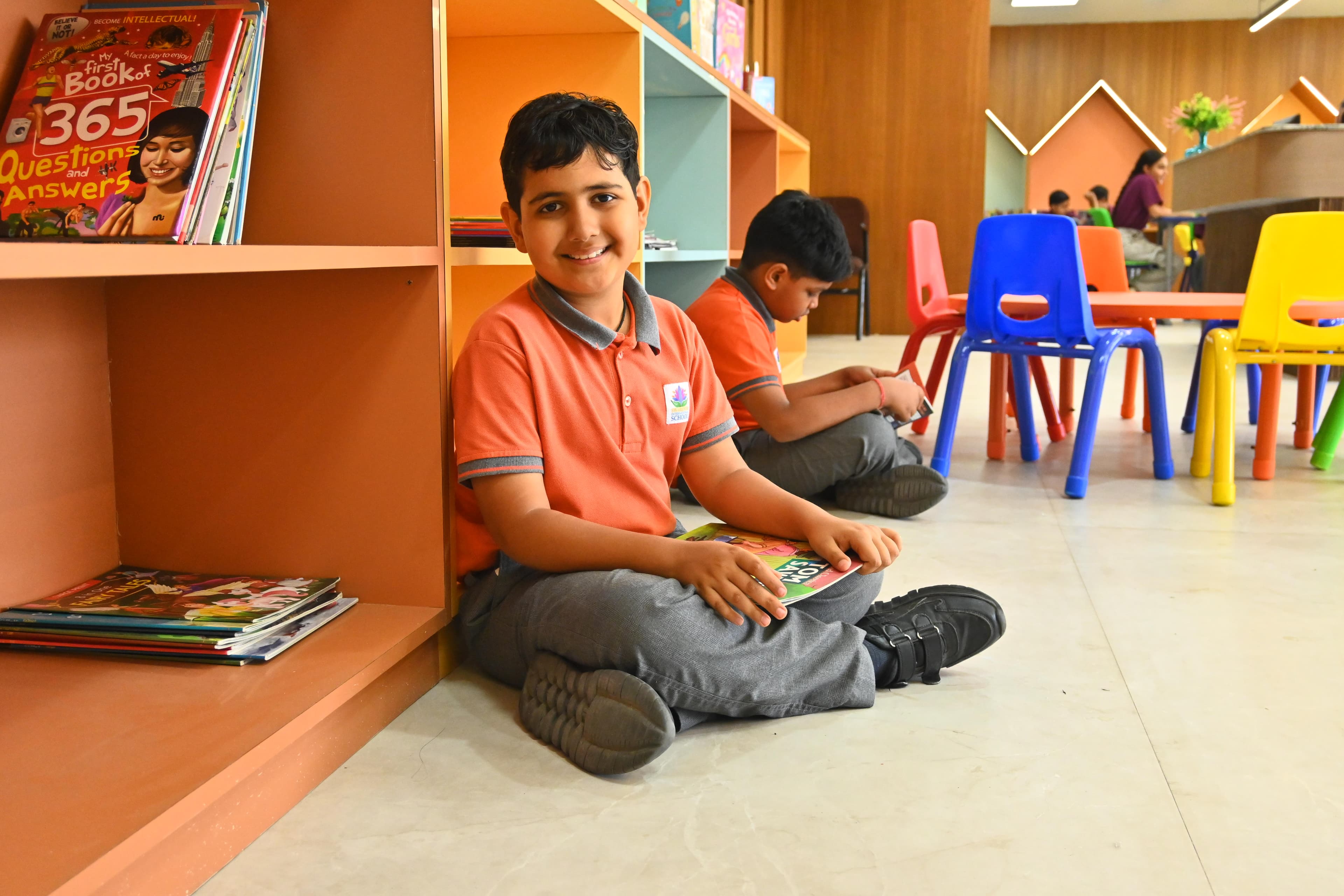 Primary school students reading independently at round colourful tables